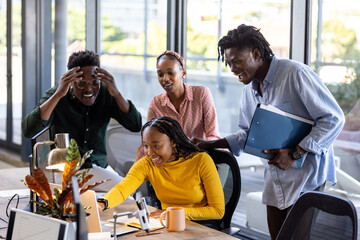 Collaborating on project in modern office, African American colleagues discussing ideas