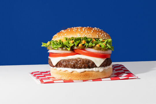 Classic cheeseburger on a blue background with vibrant colors
