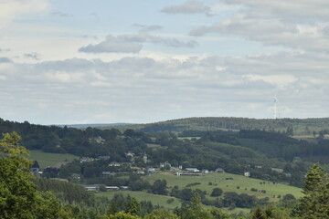 Fototapeta premium Vue panoramique du paysage de collines boisées et de champs à Bra (Lierneux)