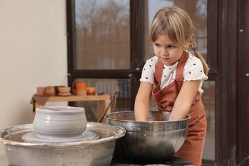 Hobby and craft. Little girl making pottery indoors
