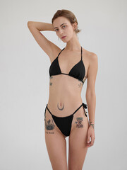 Fototapeta premium Girl model posing in studio on light background.