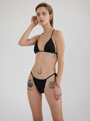 Fototapeta premium Girl model posing in studio on light background.