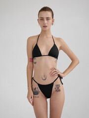 Fototapeta premium Girl model posing in studio on light background.