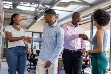 Obraz premium Colleagues in office shaking hands and smiling, building professional relationships