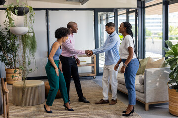 Fototapeta premium Colleagues greeting each other with handshake in modern office lounge area