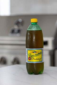 Guaran&aacute; Paulistinha bottle isolated with barbecue grill in the back