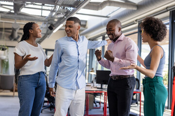 In office, colleagues celebrating success, sharing excitement and smiling together