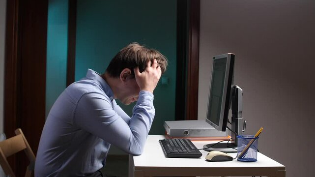 Stressed office worker pulling hair out at computer desk