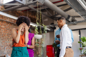 Colleagues laughing and enjoying light moment in modern office space
