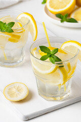 Refreshing lemon and mint beverages served on a white platter during a summer afternoon gathering