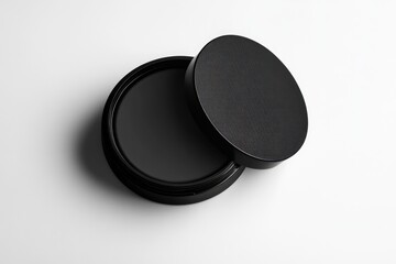 Black round cosmetic jar, slightly open, showing dark gray contents