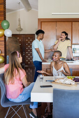 Friends sharing snacks and laughter, enjoying conversation together at home