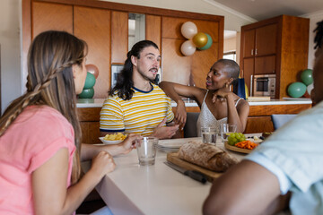 Friends enjoying conversation and snacks at home, sharing laughter and stories