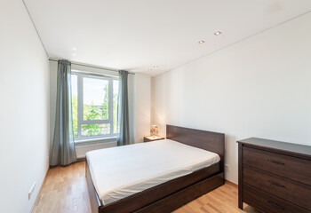 Fototapeta premium Modern Minimalist Bedroom with Wood Furniture and Natural Light