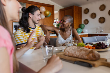 Friends enjoying conversation and snacks at home, sharing laughter and stories