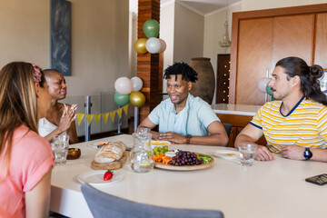 Friends enjoying conversation and sharing snacks at home during casual gathering