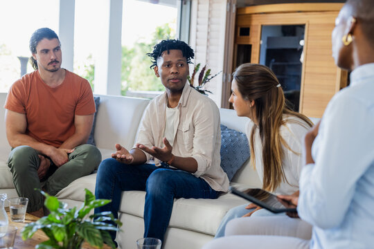 Discussing ideas, diverse friends sharing insights in thoughtful home conversation