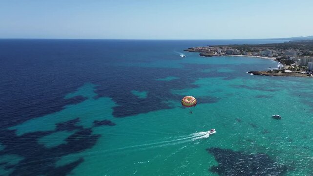 4K Aerial View of Parasailing Over Turquoise Sea &ndash; Boats and Tourists Enjoying Summer Vacation on Mediterranean Coast with Hotels, Beach, Clear Water and Sunny Weather