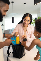 Family packing lunchbox together in kitchen, preparing for school day