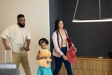 Fotobehang Family arriving home, smiling and carrying luggage and stuffed toy together © WavebreakMediaMicro