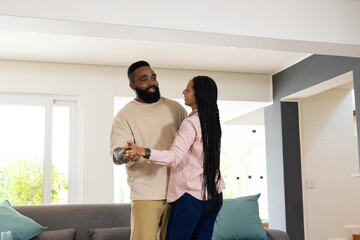African American couple dancing happily at home, enjoying quality time together © WavebreakMediaMicro