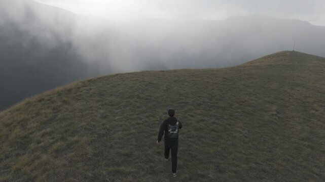 Ragazzo corre su una montagna 