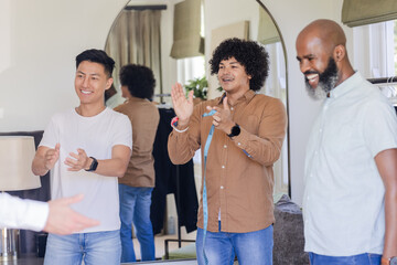 Friends celebrating together, clapping and smiling at home before wedding ceremony