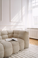 Stylish white modern interior featuring a cozy couch and natural light
