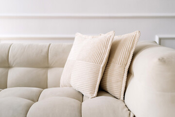 Modern white couch with soft pillows in a stylish minimalist interior setting