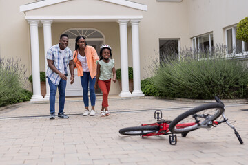 Fototapeta premium Walking towards fallen bicycle in driveway, family enjoying outdoor time together