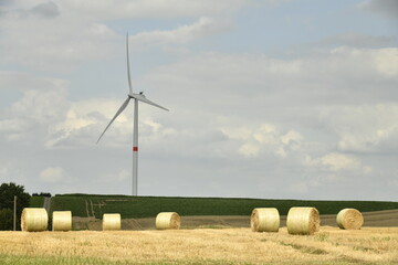 Éolienne près d'un champ de ballots de paille sous un ciel gris à Hellebecq (Silly) 