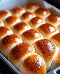 Freshly baked dinner rolls, golden brown and soft, arranged neatly in a tray. Ideal for family meals, picnics, or gatherings, these rolls offer a warm and inviting touch.