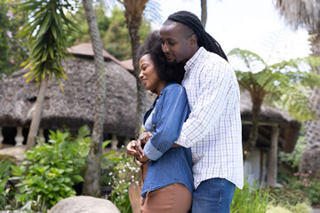Couple embracing lovingly in lush garden, enjoying peaceful outdoor moment together