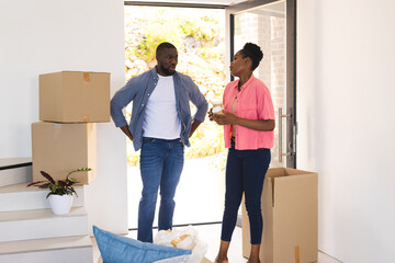 Couple discussing unpacking plans in new home surrounded by moving boxes
