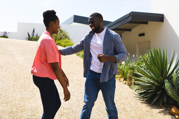 Couple enjoying outdoor conversation, smiling and embracing in sunny garden setting