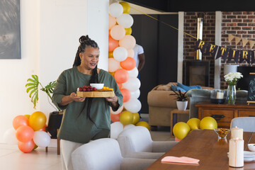 Carrying tray with snacks, woman smiling at retirement party celebration