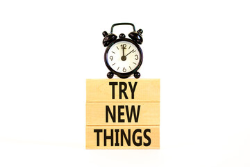 Try new things symbol. Concept words Try new things on beautiful wooden block. Black alarm clock....