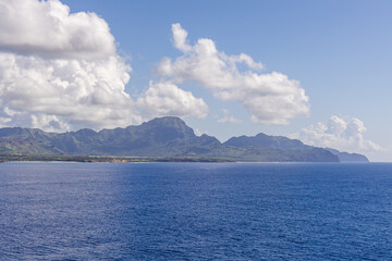 Scenic View of Kauai's Coastline with Mountain and Ocean Under a Bright Sky