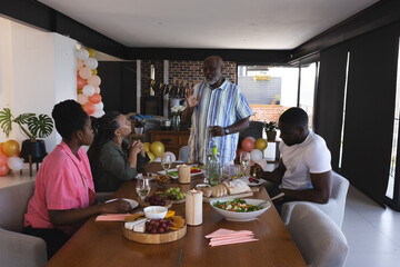 Family enjoying festive meal together, sharing stories and laughter at dining table