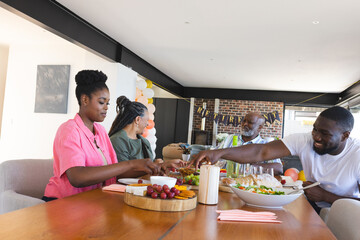 Family enjoying festive meal together at home, sharing food and laughter