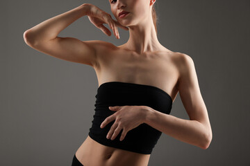 Woman with perfect slim body on grey background, closeup