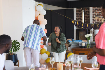 Family celebrating retirement at home, laughing and enjoying festive decorations