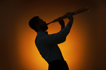 Professional musician playing soprano saxophone on color background, backlit
