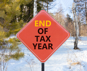 End of tax year symbol. Concept words phrase End of tax year on beautiful red road sign. Beautiful...