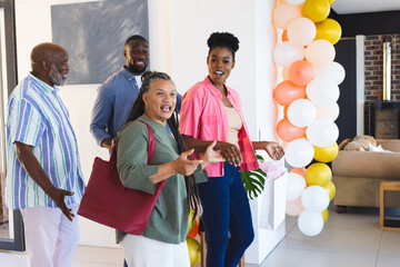 Arriving at home, family celebrating with colorful balloons and smiling together