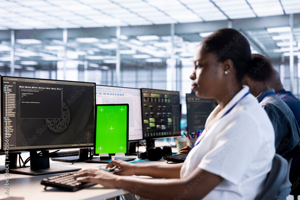 Poster worker using isolated screen tablet to check for signs of failure in data center supercomputers. tec