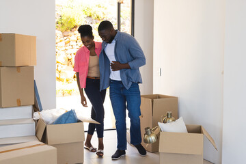 Couple unpacking boxes in new home, smiling and enjoying fresh start together