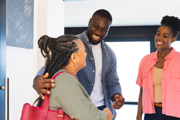 Greeting warmly at home entrance, African American family in joyful gathering