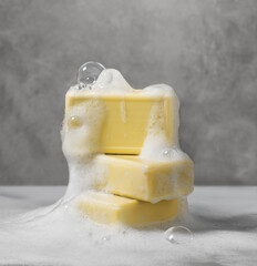 Luxurious organic soaps with charming bubbles of soap foam on the textured surface