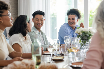 Friends enjoying conversation and laughter at wedding reception table with drinks